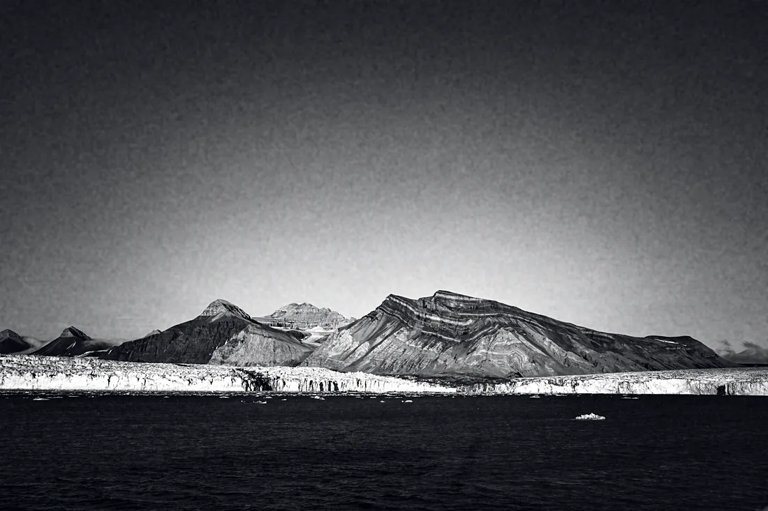 Glacier front below mountains, seen from the water